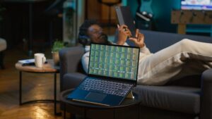 african-american-person-using-his-tablet-laying-couch-scaled.jpg